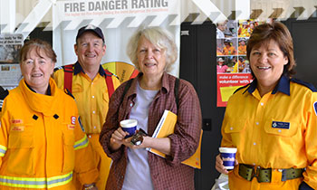Older female with cup in hand attending a community event held by Rural Fire Brigade