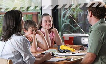 A family sitting down with items from their emergency kit