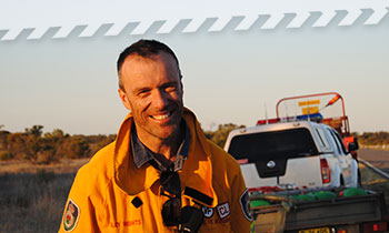 aboutus_districts.jpg A firefighter standing on the side of the road in a rural area