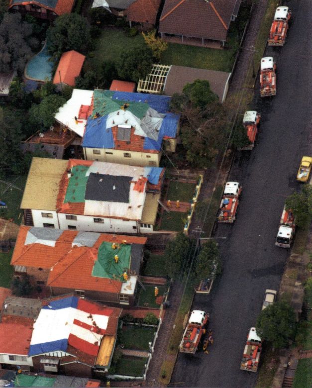 Sydney Storms, 1999 Coloured tarpaulin cover the roofs of houses damaged during the Sydney Storms, 1999