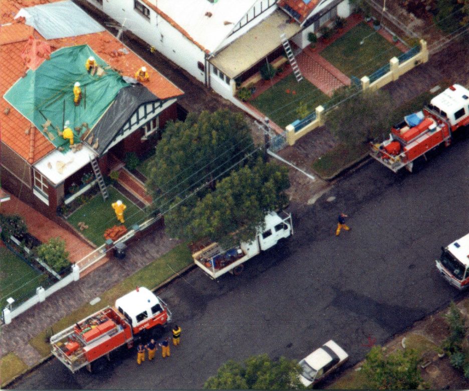 Sydney Storms, 1999 Coloured tarpaulin cover the roofs of houses damaged during the Sydney Storms, 1999